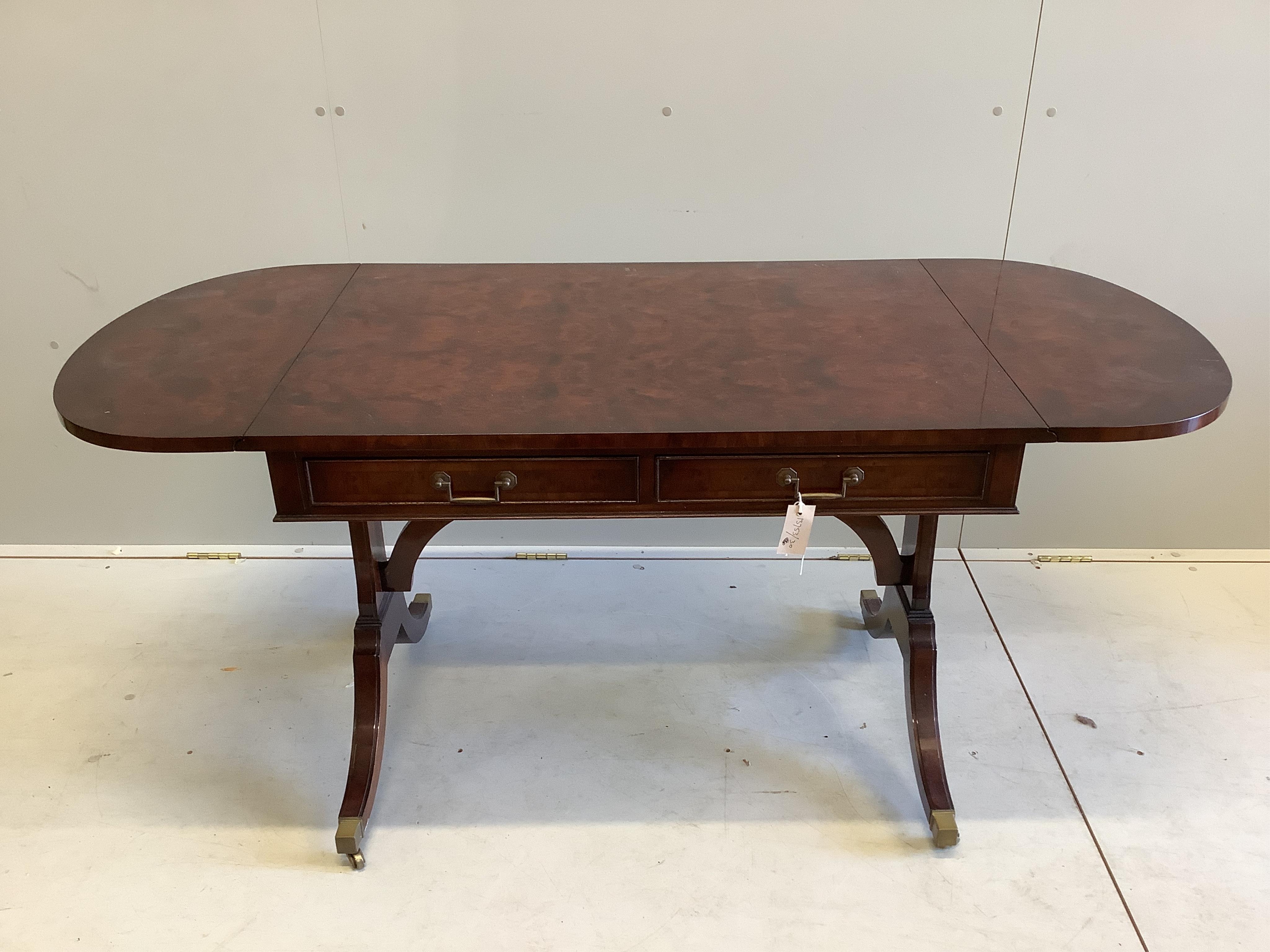A Bevan Funnell Regency style burr yew and walnut sofa table, twin flaps and two frieze drawers, on plain end standard splayed legs and brass castors, width 150cm extended, depth 66cm, height 70cm